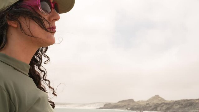 head shot portrait latin woman standing on a reck on the coast contemplating the ocean