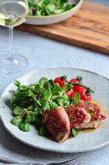 beautiful background of food served on a rustic plate, italian cuisine, veal saltimbocca, mixed salad, close up view,