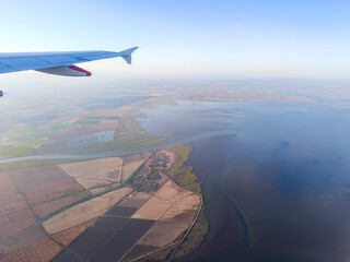 Panorama in aerial view of airplane wing flying over fields and Tagus river, Póvoa de Santa Iria PORTUGAL