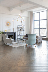 Modern luxury stylish apartment interior in pastel colors. a very bright room with huge windows filled with daylight. white walls, wooden parquet floors and a dark marble fireplace