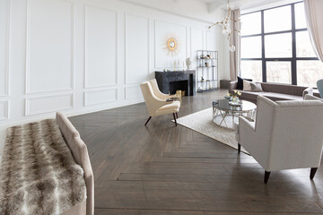 Modern luxury stylish apartment interior in pastel colors. a very bright room with huge windows filled with daylight. white walls, wooden parquet floors and a dark marble fireplace