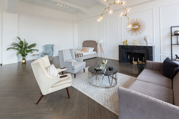 Modern luxury stylish apartment interior in pastel colors. a very bright room with huge windows filled with daylight. white walls, wooden parquet floors and a dark marble fireplace