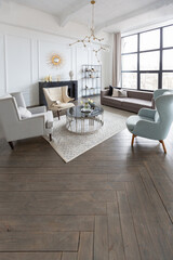 Modern luxury stylish apartment interior in pastel colors. a very bright room with huge windows filled with daylight. white walls, wooden parquet floors and a dark marble fireplace