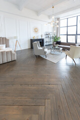 Modern luxury stylish apartment interior in pastel colors. a very bright room with huge windows filled with daylight. white walls, wooden parquet floors and a dark marble fireplace