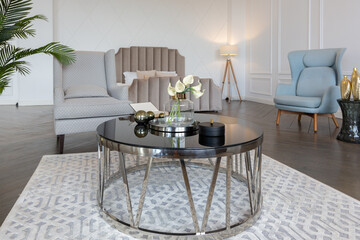 Modern luxury stylish apartment interior in pastel colors. a very bright room with huge windows filled with daylight. white walls, wooden parquet floors and a dark marble fireplace