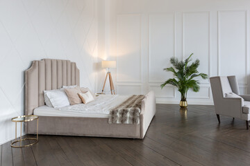 Modern luxury stylish apartment interior in pastel colors. a very bright room with huge windows filled with daylight. white walls, wooden parquet floors and a dark marble fireplace
