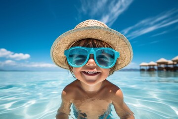 Joyful young kid smiling and having fun while swimming in the pool on a beautiful summer day