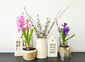 Easter composition on a white background, on the table there is a vase with willow branches and hyacinth flowers.  Space for copying text.  Happy Easter holiday concept, home interior decoration.
