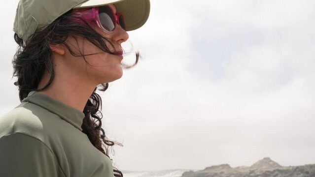 head shot portrait latin woman standing on a reck on the coast contemplating the ocean