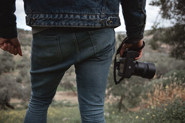 Close-up professional camera in the hands of male traveler photographer