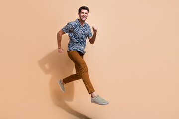 Fototapeta na wymiar Profile full body photo of energetic motivated young man workaholic running to get promotion in career islated on beige color background