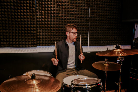 Drummer performing in studio with full drum set