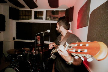 Male musicians performing in a cozy venue setting