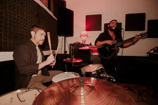 Male duo in live music session with drums and guitar