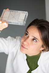 Scientist Analyzing Microtiter Plate in Laboratory