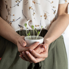 Young Seedlings Growing in a White Ceramic Bowl Held in Hands