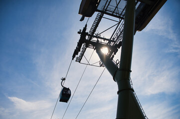 Top view of silhouette of a cable car system against the bright sky, capturing the essence of travel in Langkawi Archipelago, Malaysia