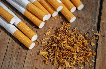 cigarettes and tobacco on wooden background