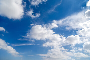 Blue sky with puffy cloud formations, natural background