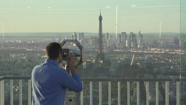 Man on telescope admiring Paris panorama from Montparnasse tower