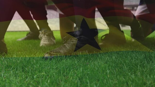 Animation of flag of ghana over legs of rugby team in scrum and ball on rugby pitch