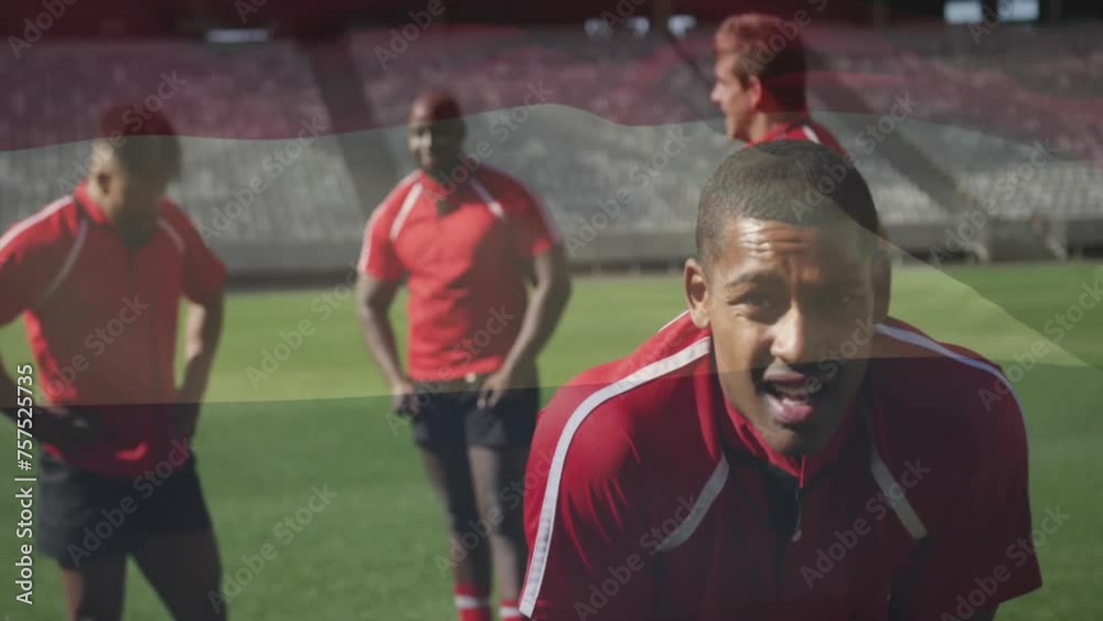 Sticker Animation of flag of hungary over tired african american rugby player on pitch with teammates