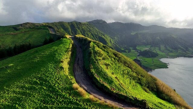4k Drone flying over green mountains of Sao Miguel island in atlantic ocean, Azores, Portugal, Europe. Overhead view of green farm meadows covering island area