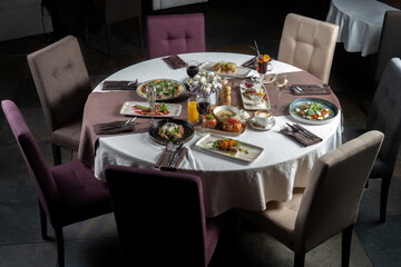 Feast table with a variety of entrees, pizza, porridge, steaks, desserts. General plan