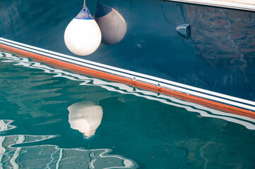 fenders suspended between a boat and dockside for protection. Maritime fenders
