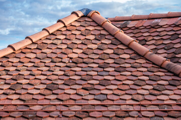 The sturdy red tiled roof, bathed in soft light, epitomizes durability and long-term protection for homes as well as weather resistance.