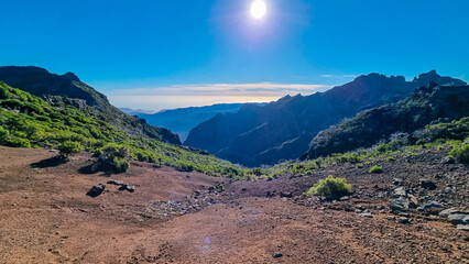 Scenic view of misty hills and cloud covered coastline of majestic Atlantic Ocean on Madeira island, Portugal, Europe. Idyllic hiking trail to mountain peak Pico Ruivo. Coastal landscape on sunny day