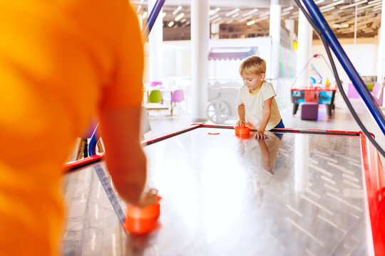 Boy playing air hockey in indoor play area.