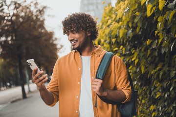 Photo of positive nice man arab traveling city watching map gps navigation spring season weather...