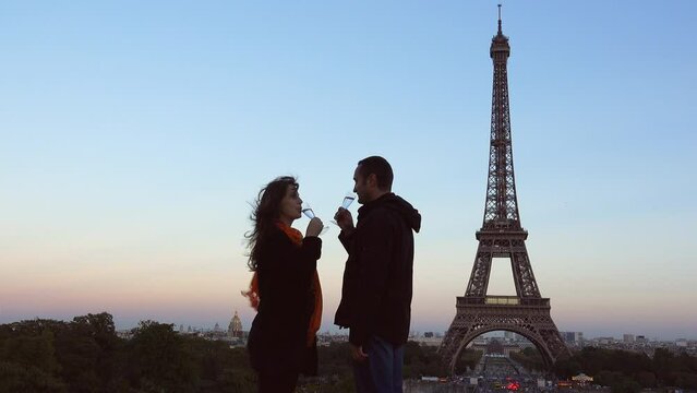 Romantic couple drinking sparkling wine in front of Eiffel Tower Paris
