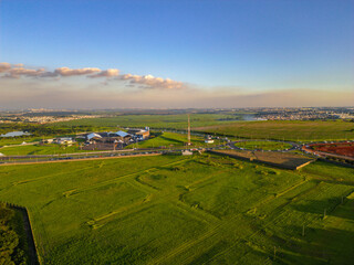 Imagem a&eacute;rea da cidade de Paul&iacute;nia (Paulinia SP) durante a hora dourada no final da tarde. Carros, condom&iacute;nios e vegeta&ccedil;&atilde;o na pequena cidade do interior.