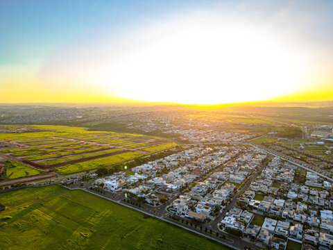 Imagem a&eacute;rea da cidade de Paul&iacute;nia (Paulinia SP) durante a hora dourada no final da tarde. Carros, condom&iacute;nios e vegeta&ccedil;&atilde;o na pequena cidade do interior.