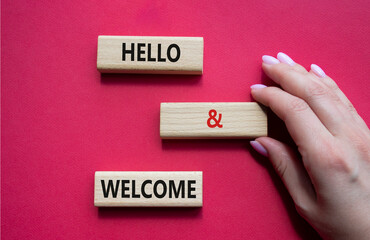 Hello and Welcome symbol. Concept words Hello and Welcome on wooden blocks. Beautiful red...