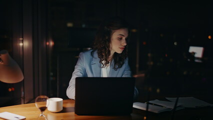 Smiling lady working late evening on laptop close up. Woman looking documents 