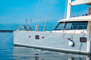 Naklejka premium hull of a modern yacht with sunbeams from the water