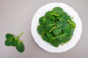 Fresh green baby Spinach leaves, diet and health concept, weight loss, spinach on ceramic plate,...