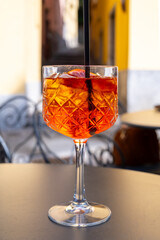 Aperol Spritz orange bitter long drink cocktail made with liqueur, prosecco sparkling wine, ice cubes and piece of orange, Milan, Italy