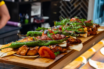 Wooden plate with Turkish mixed grill meat, chicken wings, lamb, beef shashlik, kebab, peppers from...