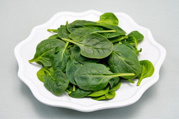 Fresh green baby Spinach leaves, diet and health concept, weight loss, spinach on ceramic plate,...