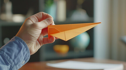 A person making a paper airplane, showing how to streamline processes in business - obrazy, fototapety, plakaty