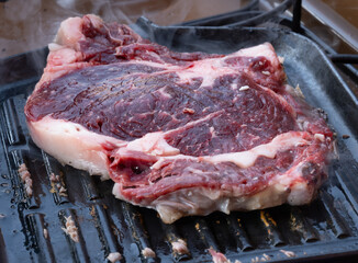 Large beef rib eye steak grilled on gas stove grill in small village restaurant in Italy