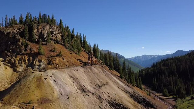 Ouray Colorado aerial scenic shot flys into abandoned mine shaft with tailings pile.  Beautiful Colorado Rockies Scenic.
