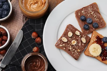 Fotobehang Different tasty toasts with nut butter and products on table, flat lay © New Africa