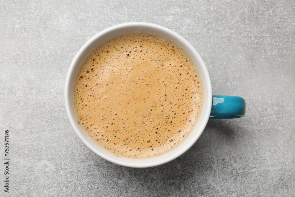 Wall mural Cup of aromatic coffee on light grey table, top view