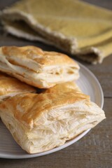 Delicious fresh puff pastries on wooden table, closeup