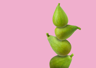 Stacked green figs on pink background, space for text